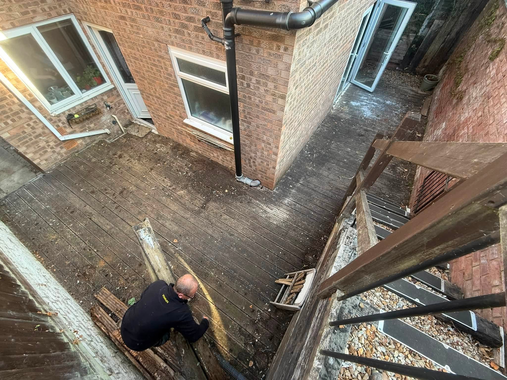 A member of the Back to Eden team at work after old decking has been lifted