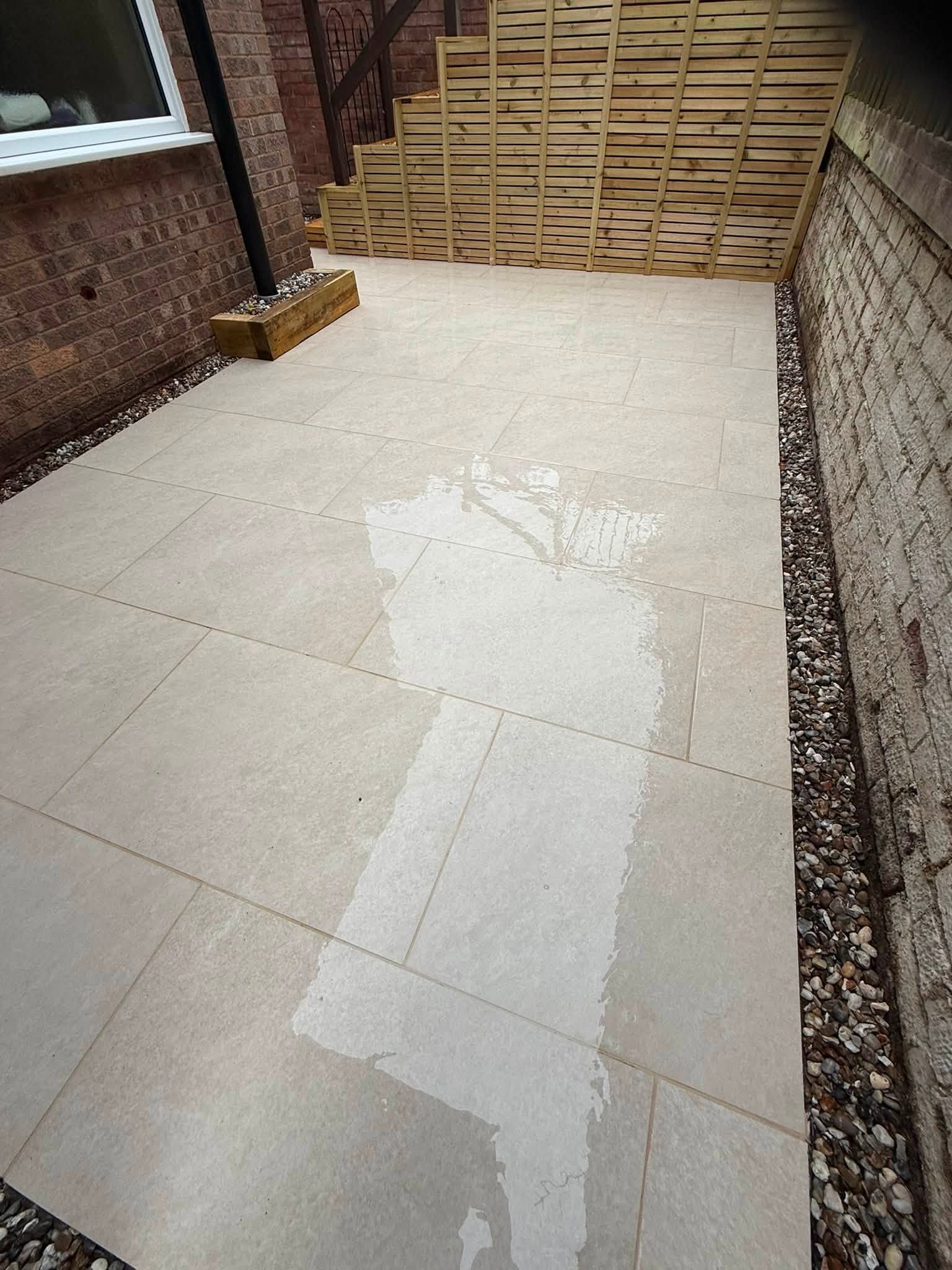 Pale paving with new fence panels along a side return