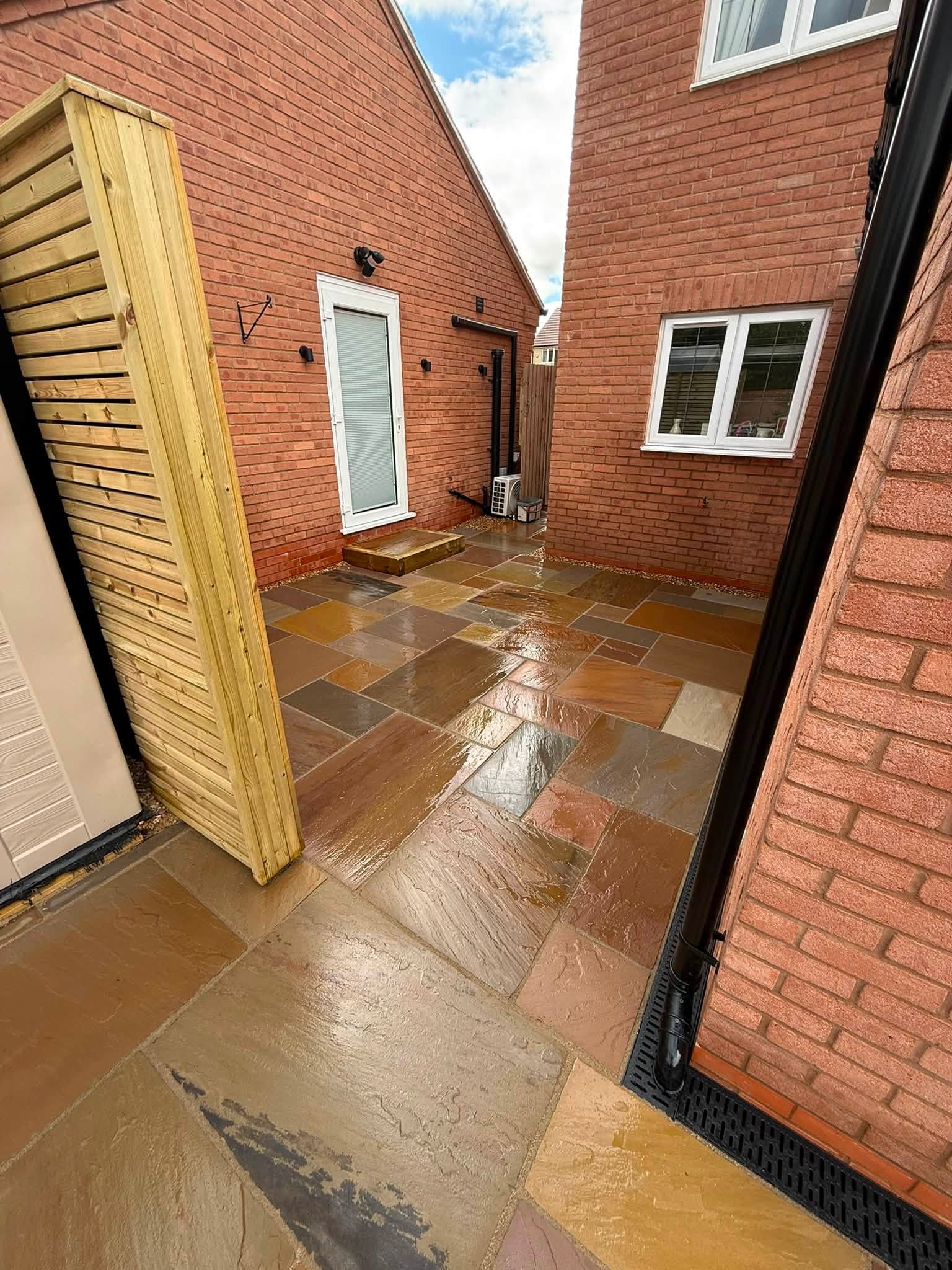 Sandstone path by a garden room after rain