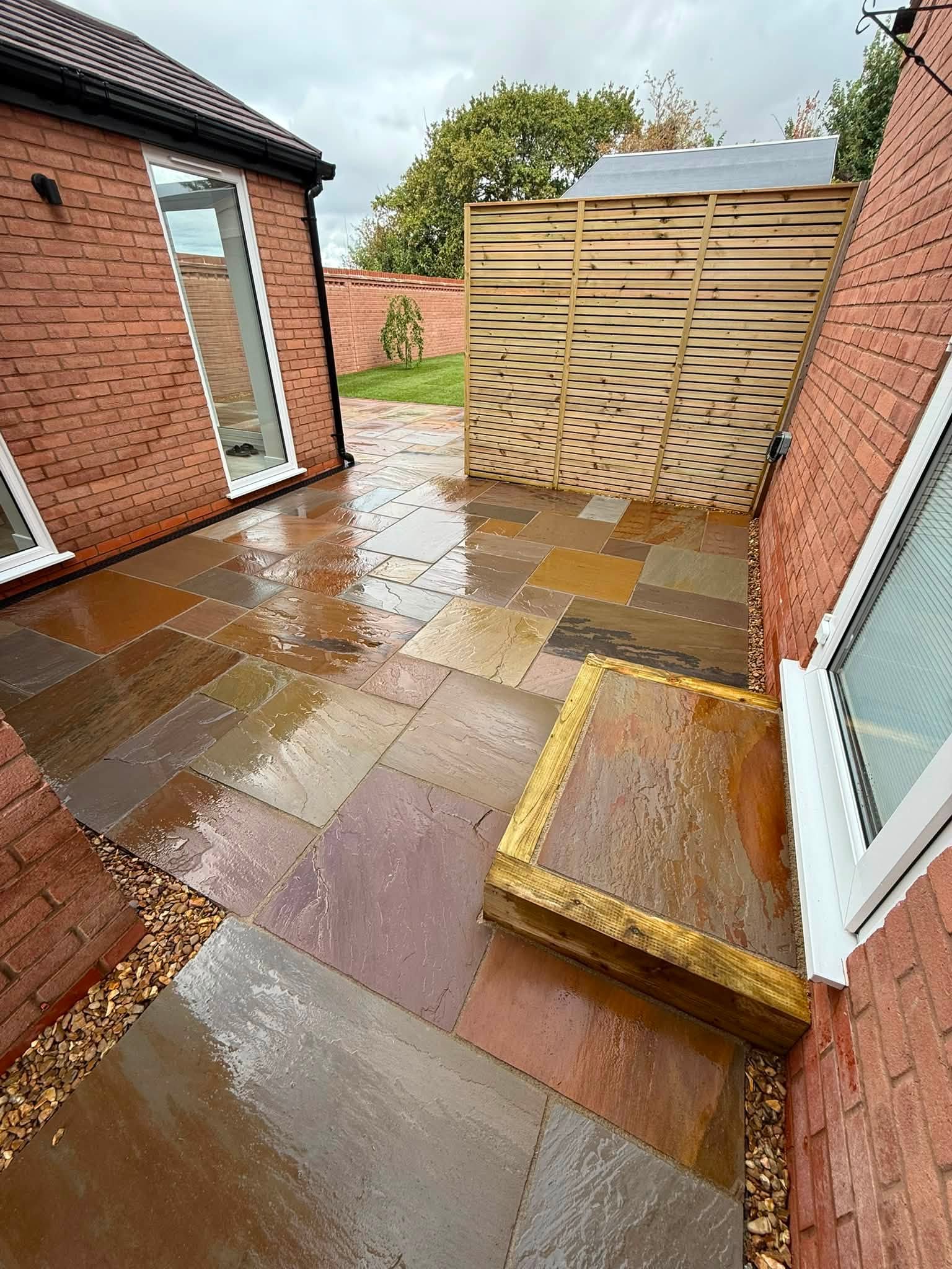 Sandstone path with a timber sleeper step beside a house