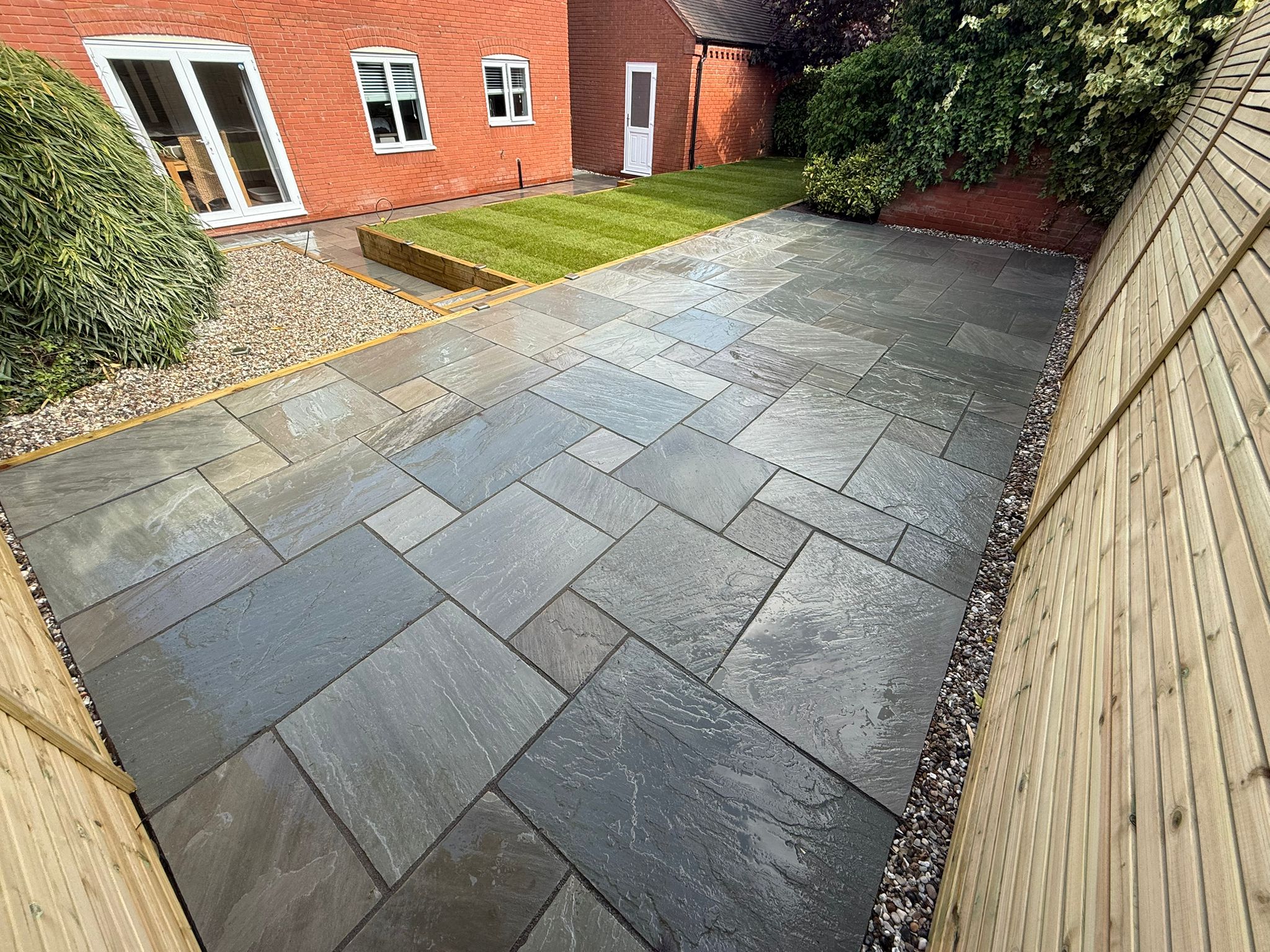 Jason Ball's finished garden: dark sandstone patio, gravel margins and a sleeper-edged lawn